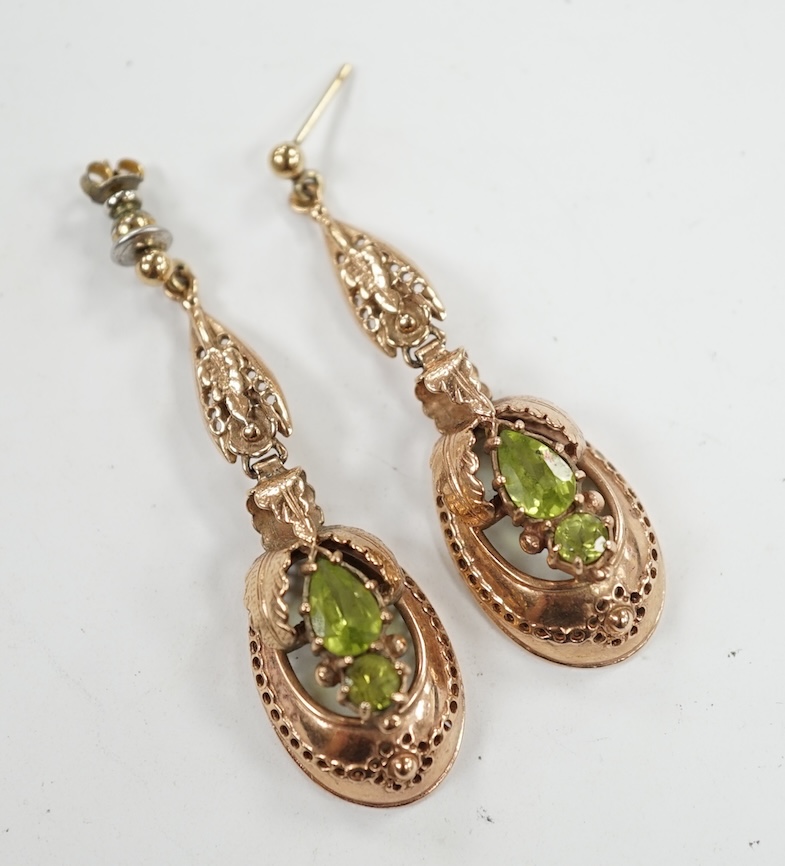 A pair of late 19th/early 20th century style yellow metal and two stone peridot set drop earrings, 48mm. Condition - poor to fair